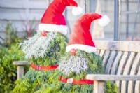 Pair of evergreen santas on a wooden bench