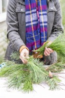 Woman placing pine sprigs over the twigs