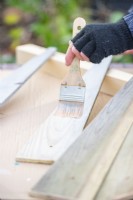 Woman painting wooden planks with a white wash