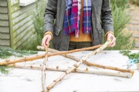Woman placing birch branches in the shape of a star