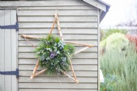 Decorative star hanging on a pale green wooden wall