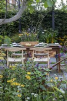 Courtyard garden with table and chairs. In foreground Rudbeckia fulgida var. sullivantii 'Goldsturm', Achillea 'Terracotta', Rudbeckia subtomentosa 'Henry Eilers', Nepeta faassenii 'Junior Walker', and Verbena bonariensis.