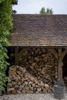 Log store with piled up logs in shed