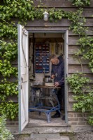 View into shed with man working at a bench
