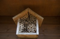 A bee hotel, set in the rafters of a summer house, attracts solitary bees. 