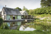 Lakeside house designed by Hugh Wray-McCann with a deck running along one side at Am Brook Meadow in Devon.