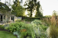 Border with herbaceous perennials and grasses at College Barn, Somerset in July