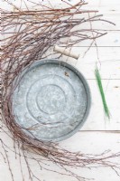 Birch sticks, circular tray and short lengths of wire laid out on a wooden surface