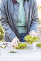 Woman placing moss on the heart frame