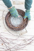 Woman placing birch sticks around the edge of the tray to create a home made wreath