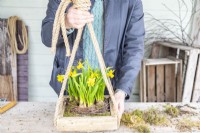 Woman holding the hanging Narcissus arrangement