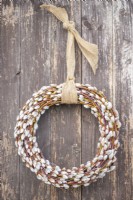 Homemade pussy willow wreath hanging on a wooden wall