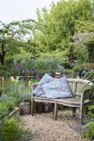 Cushions on a wooden bench in a June garden