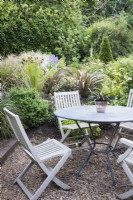 Seating area surrounded by lush foliage in June