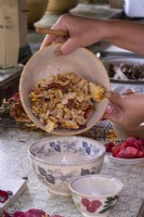 Step by step of making pot pourri, mixing in the rose petals