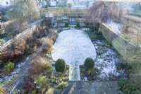 Overhead view of walled town garden in winter with box topiary and pleached field maples
