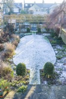 Overhead view of walled town garden in winter with box topiary and pleached field maples