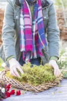 Woman placing moss around the base of the wreath