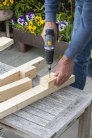 Step-by-Step Making a Potting Bench. Step 3: screw in upright supports for the lower shelf near the base of the legs