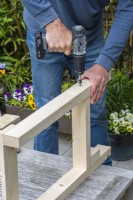 Step-by-Step Making a Potting Bench. Step 5: attach legs to support pieces that hold the bottom shelf in place, completing one of two side frames