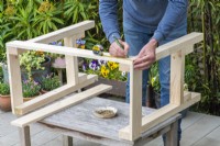 Step-by-Step Making a Potting Bench. Step 6: marking the screw holes for attaching the front panels to the top of the frame, thereby connecting the two side frames