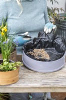 Step-by-Step Planting Wooden Flour Sieves with Spring Flowers. Step 3: line the sieve with black plastic, puncture in several places for drainage, and cover in gravel.