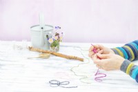 Woman tying the ends of each piece of coloured string together