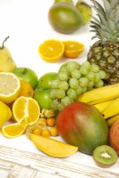 Fruit mix with grapes, pineapple, mango, bananas, apples, lemon and more, summer June