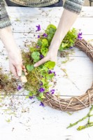 Woman tying the moss to the wreath