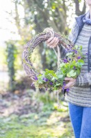 Woman holding the viola and lichen wreath