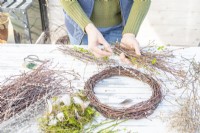 Woman making multiple bundles of the different twigs and seed heads