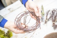 Woman weaving birch twigs into a ring