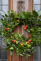 Christmas Wreath on front door, 
Arbutus fruit, Strawberry Tree, Bay foliage Myrtus Myrtle berries and foliage on wicker circle, scented leaves and berry December 