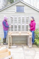 Women lifting pallet onto the bench as backing