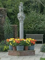 The Scottish Sundial with hedges and pots of spring-flowering bulbs Vicarage Gardens  East Ruston Norfolk