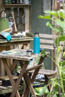 Flask on a small table by a potting shed, A Sanctuary from Covid, RHS Hampton Court Palace Garden Festival 2021