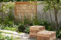 Wooden cube seats and panel made from Sweet Chestnut.  The Communication Garden, RHS Hampton Court Palace Garden Festival 2021.  Design: Amelia Bouquet.  Sponsors: London Stone, Practicality Brown, Urbis Design