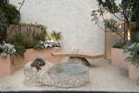  Mediterranean inspired Container garden courtyard with curved raised beds, stone bench and water feature.
