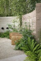 In a shady corner, the planting includes Blechnum spicant and Valeriana alliariifolia by a carved oak bench which is burnt and wire brushed, The Mind Garden - Designer: Andy Sturgeon - Sponsor: Project Giving Back.