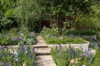 Yorkstone paved path with handmade clay tile risers, leads through planting beds to a laser cut pavilion - Morris  and  Co, RHS Chelsea Flower Show 2022 - Gold Medal