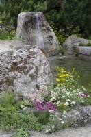 Stone boulder water feature with alpine planting - A Swiss Sanctuary, RHS Chelsea Flower Show 2022