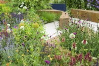Planting of white Alliums, Geum 'Totally Tangerine, Verbascum 'Petra'' and Erysimum 'Bowles Mauve' in the BBC Studios Our Green Planet and RHS Bee Garden 