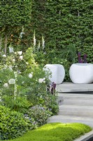 White stone seating cubes and  stone steps through green and white herbaceous planting  with Alliums, Foxgloves and Lupins - The Perennial Garden With Love