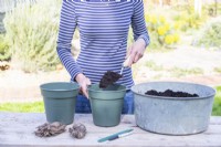 Woman filling pots with compost