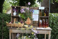 An English village flowershow competition display of garden produce including flowers, vegetables, homemade apple juice and cider.