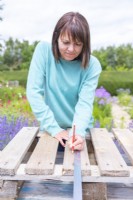 Woman marking the planks at lengths of 39 cm