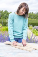 Woman sanding the edges of the planks
