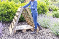 Woman positioning the pallets to form a triangle