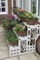 Art Deco etagere full of colourful pots at Hamilton House garden in May 