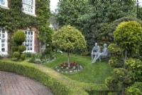 Front garden with wire sculptures by Derek Kinzett and cloud trees at Hamilton House garden in May 